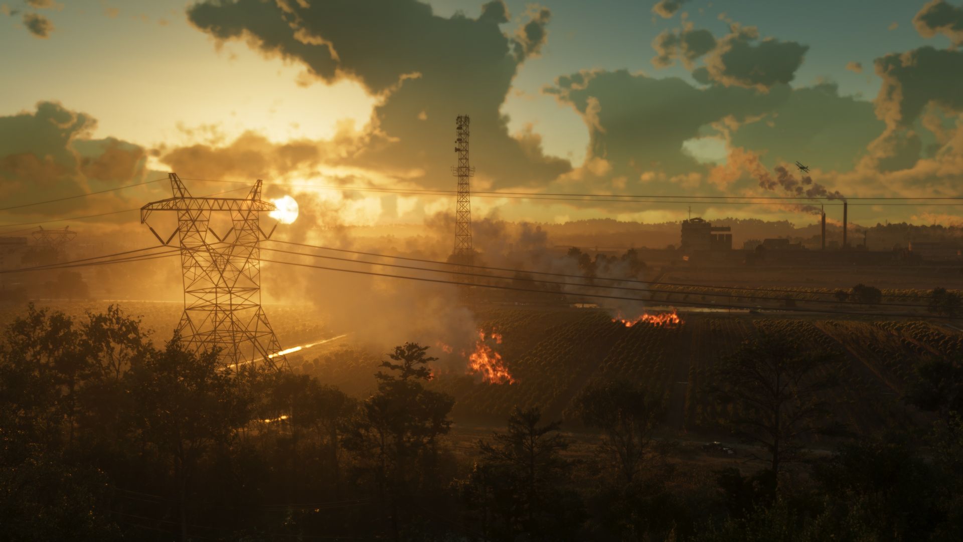 Power lines and an industrial skyline against a low orange sun