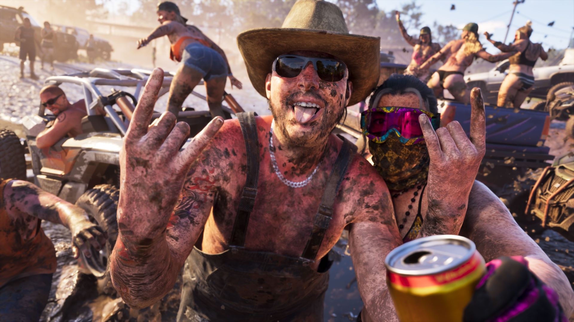 Ein schlammbespritzter Mann mit Cowboyhut macht bei einem Schlammrennen ein Selfie, dahinter Trucks