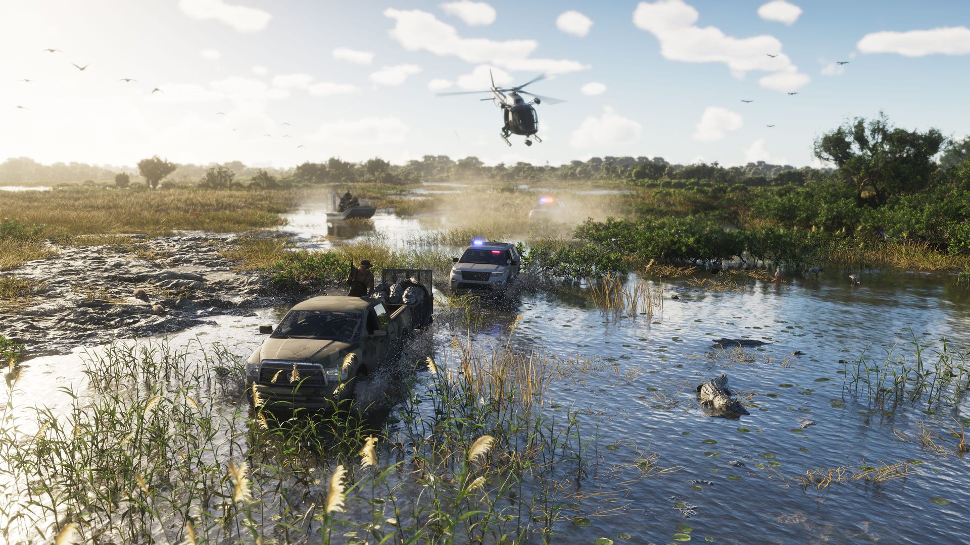 Off-road trucks push through shallow wetland water as a helicopter flies low overhead