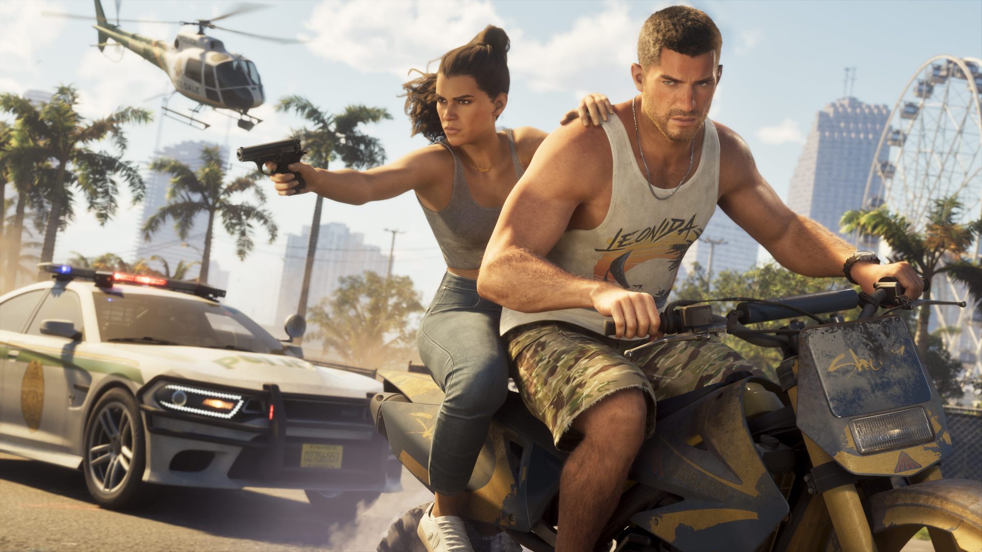 Jason rides a dirt bike with Lucia behind him aiming a pistol, a police car and a helicopter in pursuit along a palm-lined road
